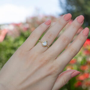 Sortija Mónaco en Oro Blanco con Un Halo Pavé que Resplandece con las Luces de la naturales en la mano de la novia