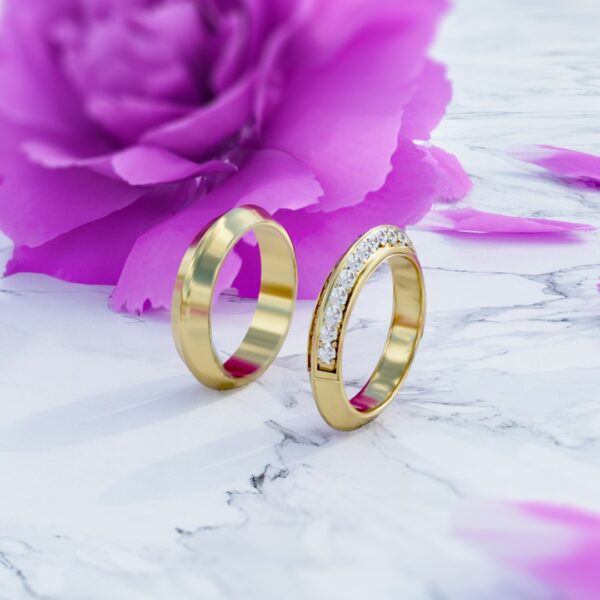 Anillos en oro de 18k de matrimonio modelo be my darling con diamantes en posición vertical en fondo de flor