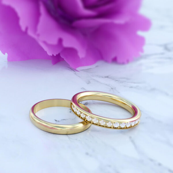 anillos de matrimonio para hombre y mujer en oro de 18k de matrimonio modelo be my love con diamantes en posición horizontal en fondo de flor