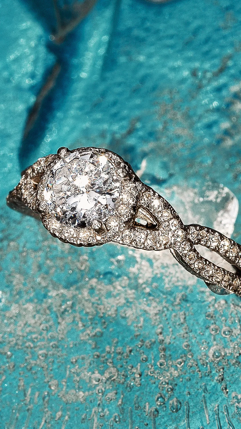 Anillo de platino con halo de diamantes y banda entrelazada