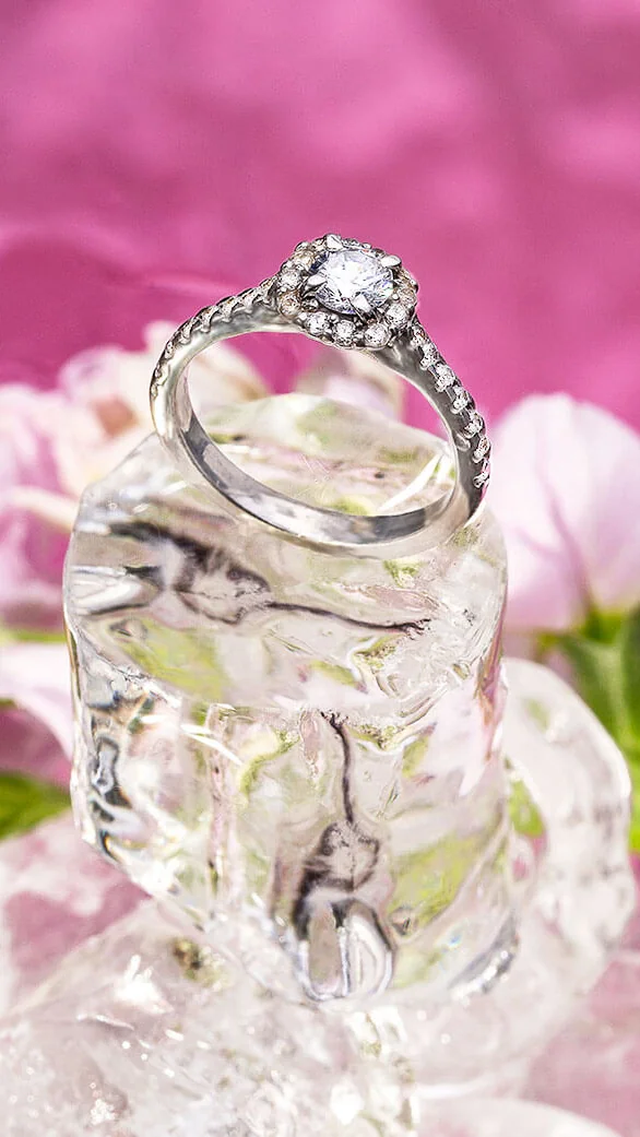 Anillo de platino con halo de diamantes entre flores