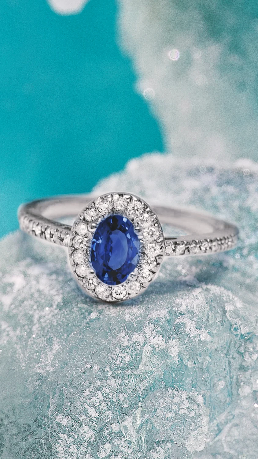 Anillo de platino con zafiro azul ovalado y halo de diamantes